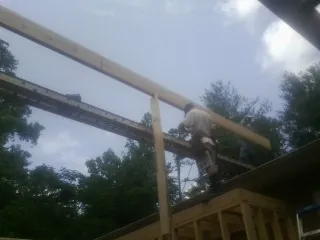 Carpenter setting a ridge beam over a new addition frame — Ice Dam Removal by Roofing Brothers in Paxton