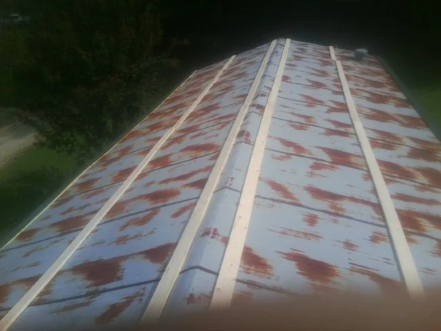 Rusted metal roof panels with new wood purlins before replacement — Storm Damage Roof Repair in Paxton by Roofing Brothers