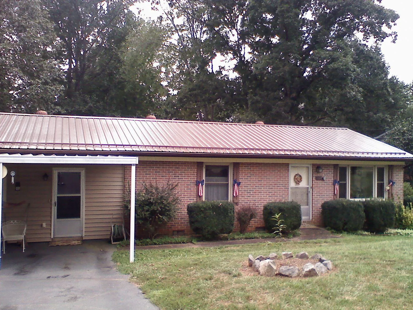 Bronze metal roof and carport on a brick ranch home — Roof Repair work by our crew in Paxton